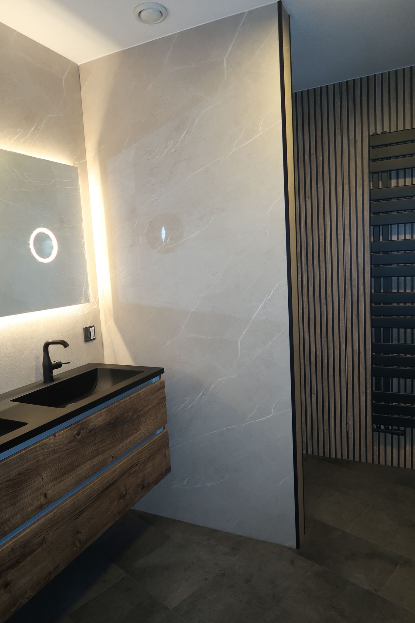 Moderne badkamer met houten wastafelmeubel, LED-spiegel en marmerlook tegels