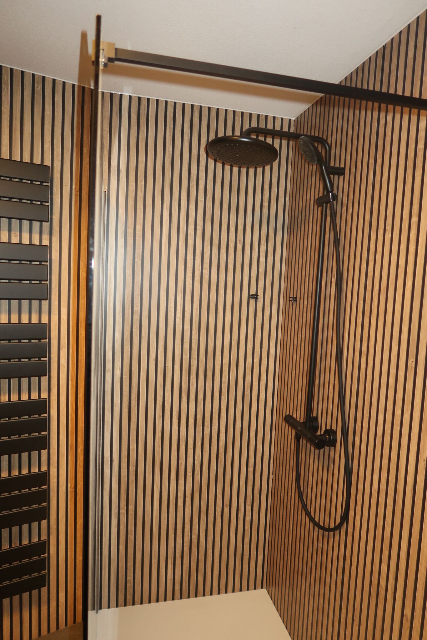 Luxe inloopdouche met regendouche en houtlook wandpanelen