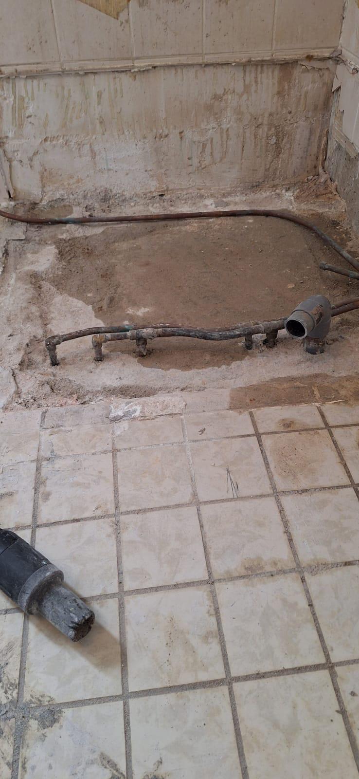 Badkamerrenovatie in uitvoering: oude leidingen en verwijderde tegels